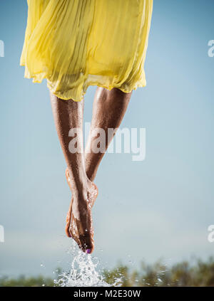 Feet of Black dancing jumping in water Stock Photo