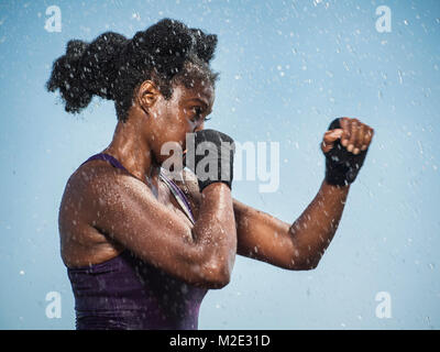 Water splashing on sparring Black woman Stock Photo