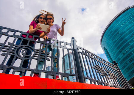 Caucasian women posing for selfie near railing using digital tablet Stock Photo