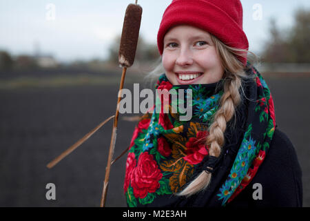 Portrait of smiling Caucasian woman wearing scarf and stocking-cap Stock Photo