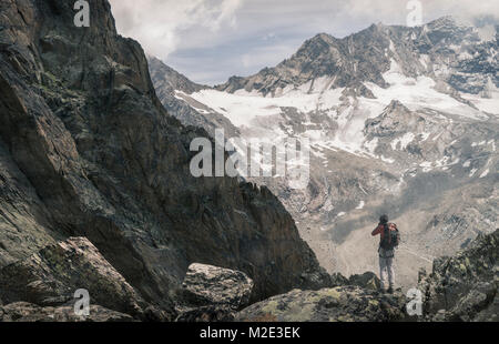 Caucasian man hiking on snowy mountain Stock Photo
