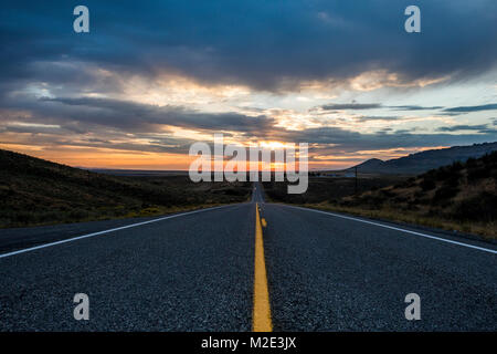 Empty remote road at sunset Stock Photo