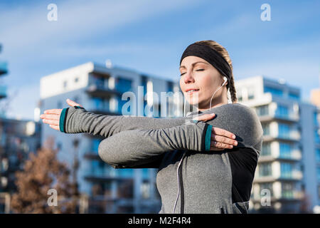 Portrait of a determined young woman stretching her left arm Stock Photo