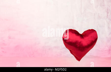 Satin heart on light red background.Valentine's Day concept Stock Photo