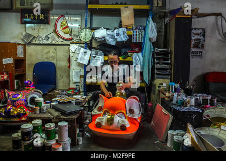 SUBANG, MALAYSIA - FEBRUARY 07: A chinese man work with Lion head inside the Wan Seng Hang (WSH) Dragon & Lion Arts workshop in Subang outside Kuala Lumpur on February 7, 2018. WSH produce around 500 lion heads per year with some being exported to Asia including Taiwan, Japan, Hong Kong, United States and around the world. The traditional Lion Head certain combinations of colour and design were created as a tribute to famous Chinese historical, entire process is done by hand and rattan is used to form the skeletal structure of the head with layers of bamboo paper. The price of a complete set Stock Photo