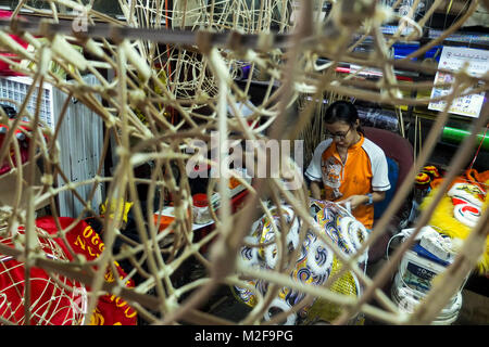 SUBANG, MALAYSIA - FEBRUARY 07: A chinese women work with Lion head inside the Wan Seng Hang (WSH) Dragon & Lion Arts workshop in Subang outside Kuala Lumpur on February 7, 2018. WSH produce around 500 lion heads per year with some being exported to Asia including Taiwan, Japan, Hong Kong, United States and around the world. The traditional Lion Head certain combinations of colour and design were created as a tribute to famous Chinese historical, entire process is done by hand and rattan is used to form the skeletal structure of the head with layers of bamboo paper. The price of a complete set Stock Photo