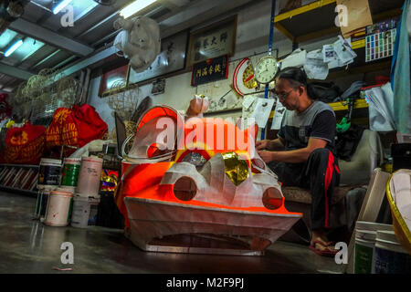 SUBANG, MALAYSIA - FEBRUARY 07: A chinese man work with Lion head inside the Wan Seng Hang (WSH) Dragon & Lion Arts workshop in Subang outside Kuala Lumpur on February 7, 2018. WSH produce around 500 lion heads per year with some being exported to Asia including Taiwan, Japan, Hong Kong, United States and around the world. The traditional Lion Head certain combinations of colour and design were created as a tribute to famous Chinese historical, entire process is done by hand and rattan is used to form the skeletal structure of the head with layers of bamboo paper. The price of a complete set r Stock Photo