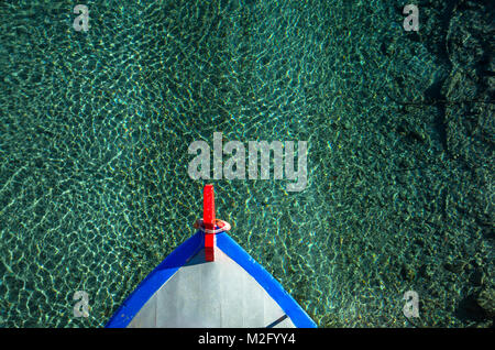 View from the top of a bow of a wooden fishing boat sailing on a crystal sea. Stock Photo