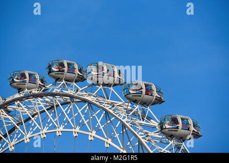 Pods of the Coca Cola London Eye Millennium Wheel in blue sky. London tourist attraction with tourists in capsules Stock Photo