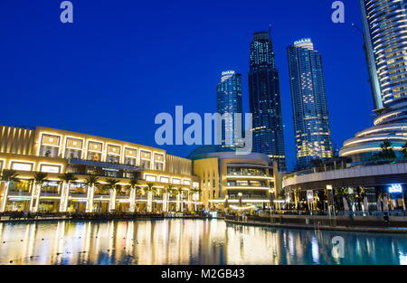 DUBAI, UNITED ARAB EMIRATES - FEBRUARY 5, 2018: Dubai mall modern architecture reflected in the fountain at blue hour. The Dubai Mall is the largest m Stock Photo