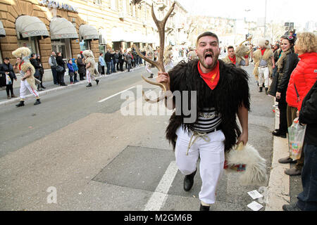 Carnival A maniac - a man masked in a sheep's skin holding a horn of a deer and belching Stock Photo