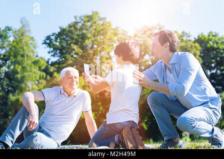 Mindful father teaching son how to take photos Stock Photo