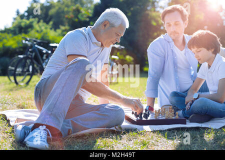 Mindful grandfather playing chess with grandson Stock Photo