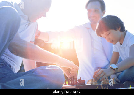 Friendly family playing chess together Stock Photo