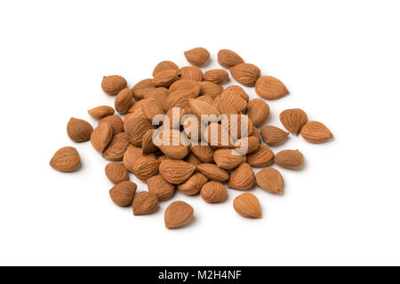 Heap of dried apricot stones isolated on white background Stock Photo