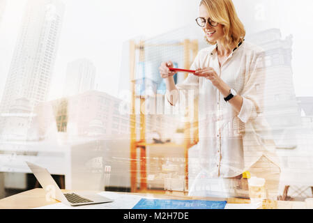Cheerful engineer making a photo of her sketch Stock Photo - Alamy