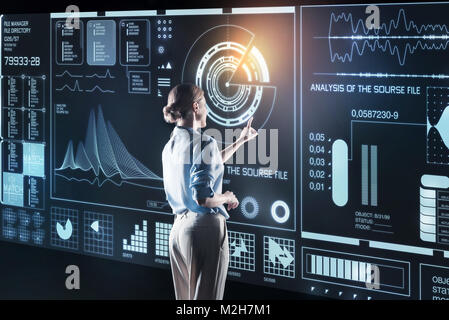 Experienced programmer looking elegant and standing in front of a giant screen Stock Photo