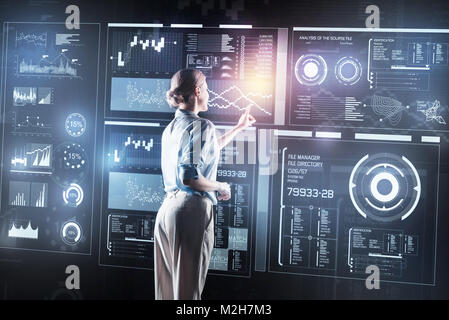 Attentive young woman making necessary changes in a new program while working Stock Photo