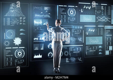 Young woman wearing high heeled shoes standing in front of futuristic gadget Stock Photo