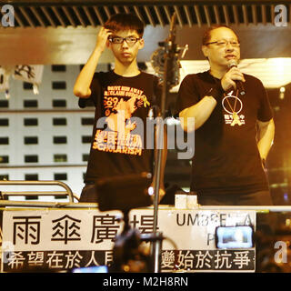 Joshua Wong Chi-fung (l), leader and founder of the student activist group Scholarism, and Benny Tai Yiu-ting (r), co-founder of the Occupy Central movement, speak from the podium. Stock Photo