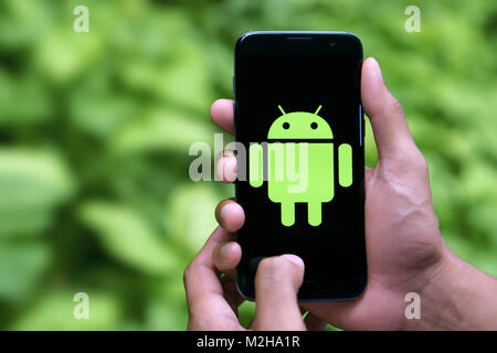 Man holding android mobile with logo Stock Photo