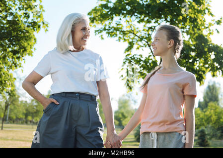 Positive nice grandmother and granddaughter holding hands Stock Photo