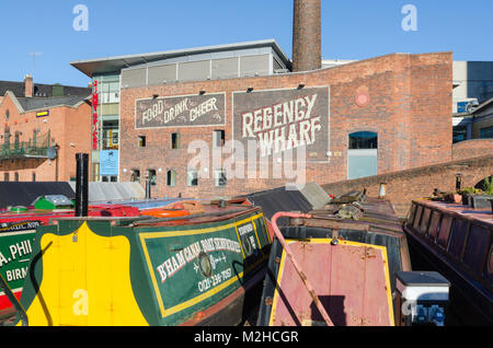 Colourful narrowboats moored in Gas Street Basin in the heart of the canal network in Birmingham, UK on a sunny winter's day Stock Photo