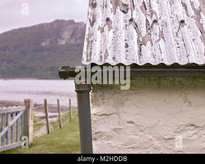 Detail of corrugated iron roof, cast iron guttering and down pipe on the shore of Loch Carron at Ardaneaskan Clachan Cottage. Stock Photo