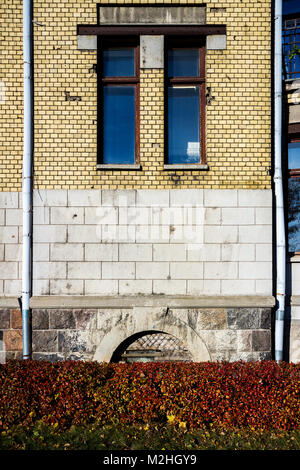 Old yellow street wall with some small windows Stock Photo