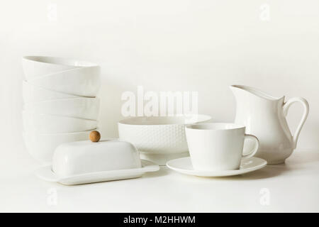 Crockery,dish, tableware, utensils and other different white stuff on white table-top. Kitchen still life as background for design. Image with copy sp Stock Photo