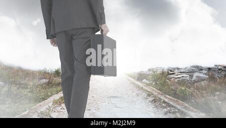 Businessman holding briefcase on path Stock Photo