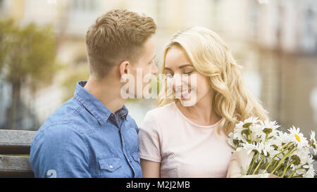 Beautiful blonde girl smiling to beloved man, holding nice bunch of flowers, stock video Stock Photo