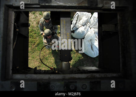 Port Fourchon, La. – Louisiana National Guard Soldiers of the 769th Engineering Battalion hookup a wire sling to an UH-60 Blackhawk helicopters belonging to the 1/244th Assault Helicopter Battalion in Hammond, La, sling load several thousand pound sandbags to Trinity Island to fill in a low lying area critical to oil spill mitigation efforts along Louisiana’s shoreline, May 27, 2010. Trinity Island is one of many barrier islands along the coast of Louisiana that are threatened by the oil spill. (U.S. Air Force Photo by Master Sgt. Toby M. Valadie, Louisiana National Guard State Public Affairs  Stock Photo