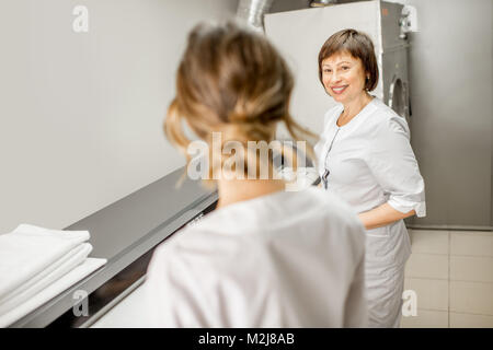 Laundress working with ironing machine Stock Photo