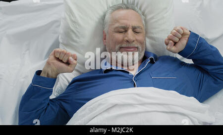 Happy senior male waking up in good mood at home after nice calm night, stock footage Stock Photo