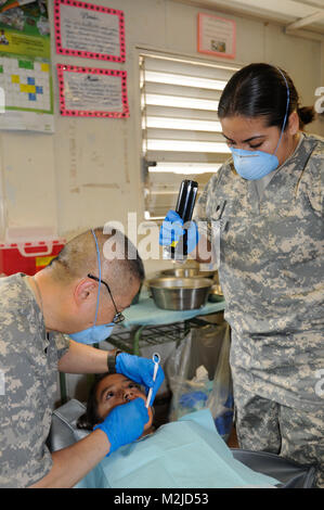 Maj. George Wan from Los Angeles and Spc. Nancy Cardenas from Lancaster, Calif. check a child's teeth in El Salvador.  The 349th Combat Support Hospital treated people at three clinics in and around the San Vicente area during a two week medical mission.  - Photo by Staff Sgt. Kristen King 349th MEDRETE in San Vicente (27 of 88) by 807MCDS Stock Photo