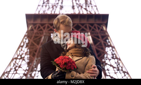 Sweet couple hugging tenderly on romantic date, pretty girl with roses bouquet, stock footage Stock Photo