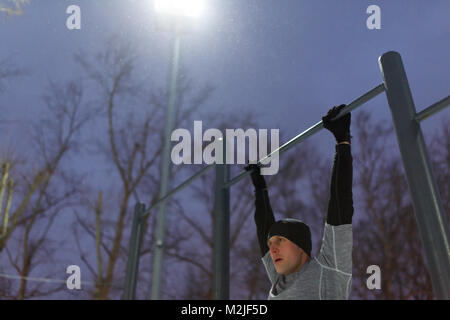 Photo of athlete pulling on bar in evening Stock Photo