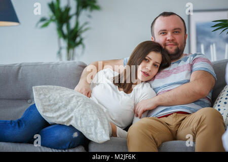 Photo of hugging couple on gray sofa Stock Photo