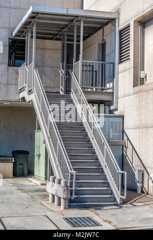 Vertical shot of a metal staircase behind an industrial building. Stock Photo