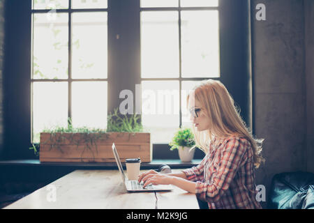 Side profile half-faced photo of busy concentrated smart clever beautiful woman wearing checkered shirt and glasses, she has remote work, typing on la Stock Photo