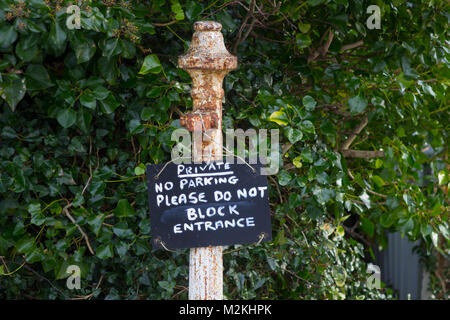 A polite no parking request hanging on a cast iron post at the entrance to a private dwelling Stock Photo
