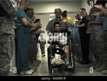 JOINT BASE BALAD, Iraq -- Medical personnel applaud as Ahmad, a 14-year-old Iraqi victim of a mortar explosion, leaves the Air Force Theater Hospital here Sept. 17, 2009, after spending more than a month recovering from his injuries. (U.S. Air Force photo/Staff Sgt. Heather Norris) 090930-F-9999A-002 Stock Photo