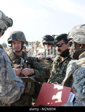 NANGARHAR PROVINCE, Afghanistan – U.S. Army 1st Lt. Fernando E. Roach, 1st Squadron, 108th Cavalry Regiment contracts officer from Washington, D.C. (right); Capt. Abdul Samad, Afghan National Army Weapons COY, 2nd Kandak, 201st Corps Commander;  U.S. Marine Sgt. William M. Rowe, 3rd Marine Div., supply noncommissioned officer and a mentor for the ANA’s Weapons COY from Dayton, Ohio (center); and U.S. Marine Maj. J.P. McDonough, 3rd Marine Div. and Embedded Training Team officer in charge from St. Louis, Mo., finalize security and processes with U.S. Air Force civil engineers, during the joint  Stock Photo