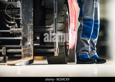 Operating Forklift Truck. Men and the Machine. Professional Lift Truck Operator Concept Photo. Stock Photo