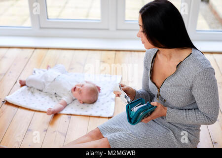 Woman and baby with money worries Stock Photo