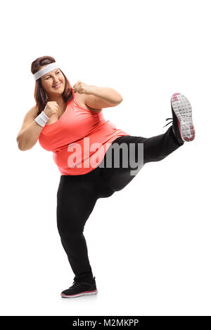 Full length portrait of an overweight woman kicking isolated on white background Stock Photo