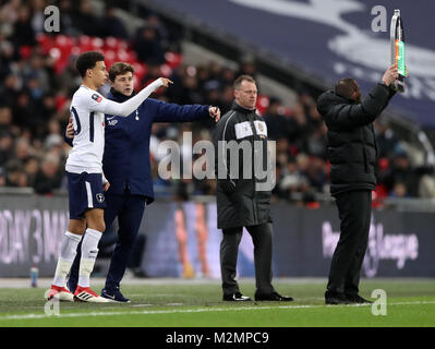 Tottenham Hotspur manager Mauricio Pochettino talks to Dele Alli before he is subbed on during the Emirates FA Cup, fourth round replay match at Wembley Stadium, London. Stock Photo