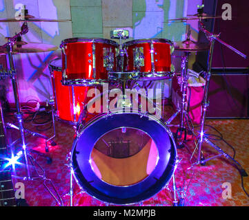 Modern drum set on stage prepared for playing in bright blue light Stock Photo