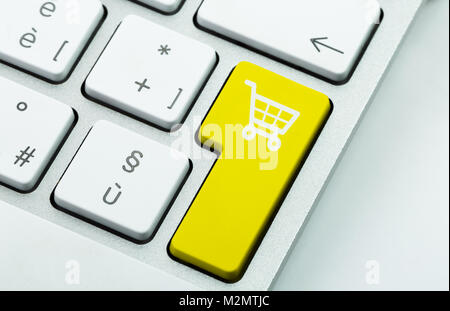 Computer notebook keyboard with icon shopping cart on key. E-commerce concept Stock Photo